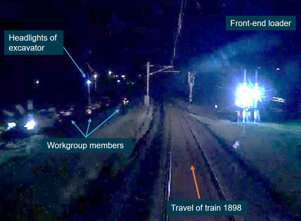 Figure 2: View from train 1898 showing the work group, front-end loader, and headlights of the excavator in the distance