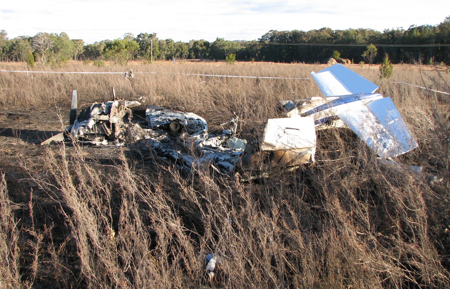 Figure 4: Aircraft wreckage showing the tail empennage inverted to the right and the propeller visible on the left (looking south-south-west)