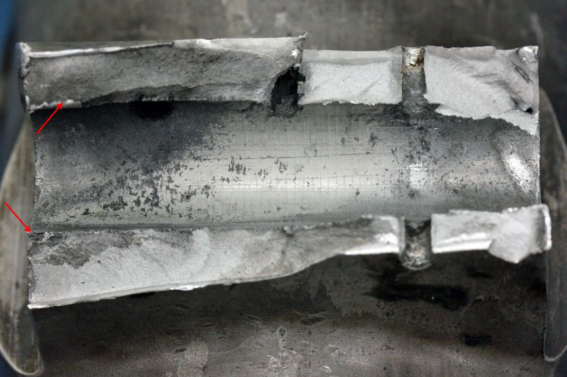 Figure 5: Yoke lug exhibiting corrosion pitting, wear in the bore and fatigue crack progression on the fracture surfaces (main crack origins arrowed)