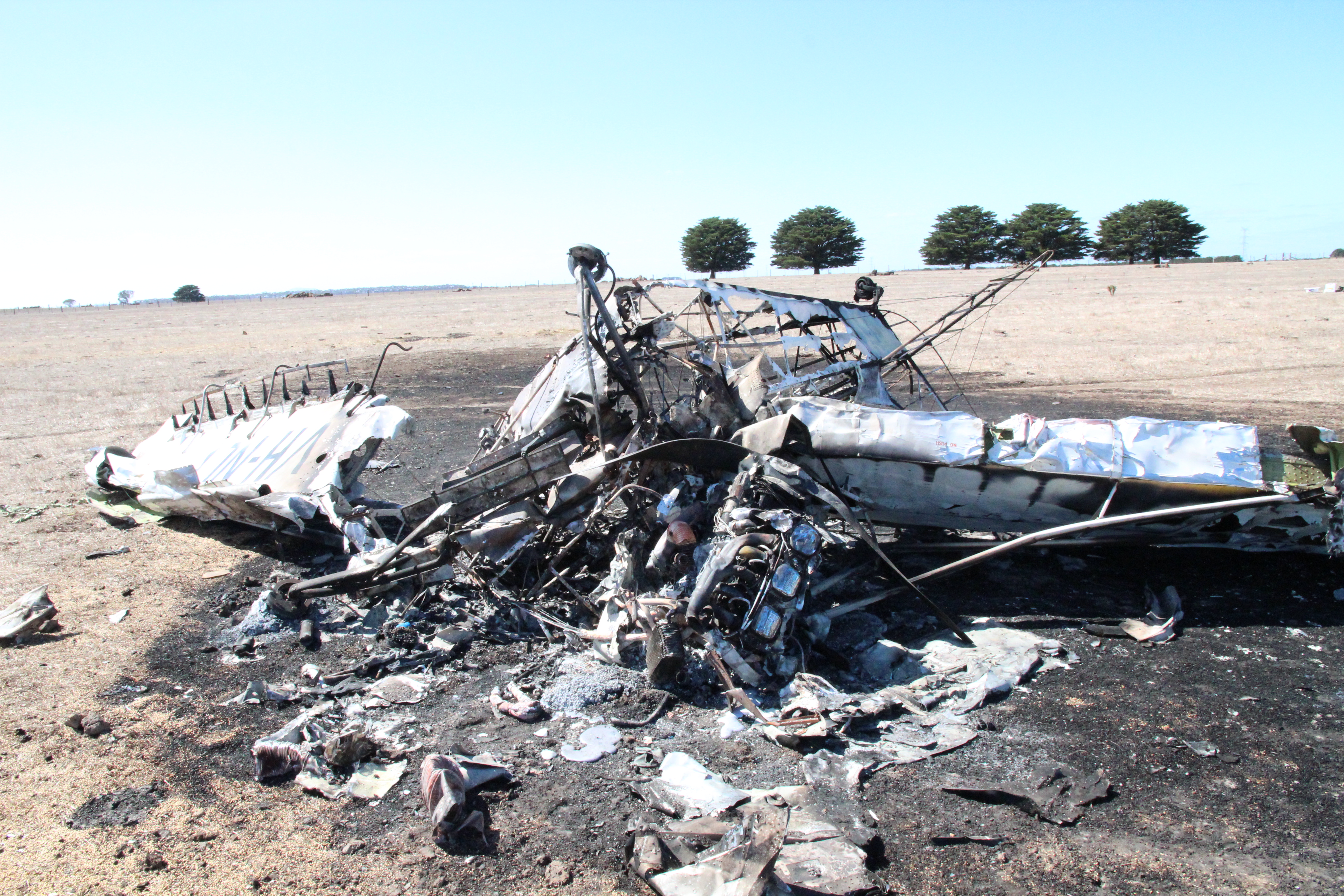 Figure 1: Aircraft wreckage (looking east), showing the lower surface of the aeroplane. Note the significant damage to the forward fuselage and cockpit area and the extent of the fire damage to the fuselage and inboard wing sections