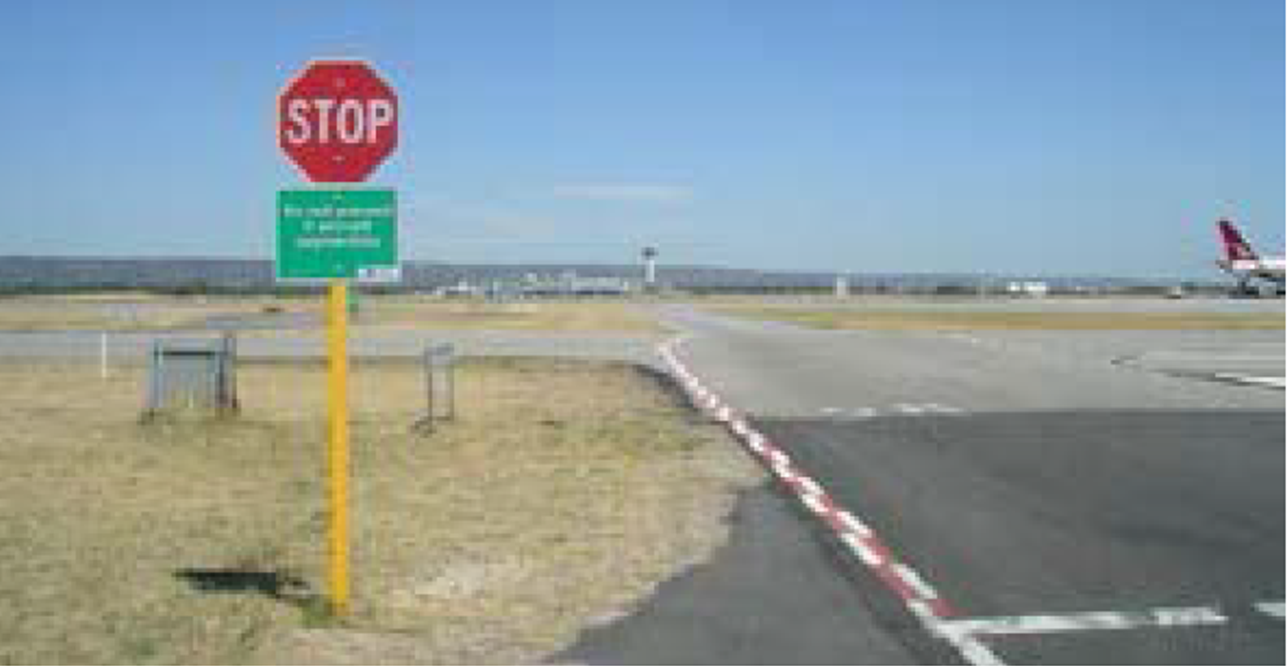 Figure 2: Photo showing stop sign and red and white zipper markings that denote a taxiway like that for taxiway R