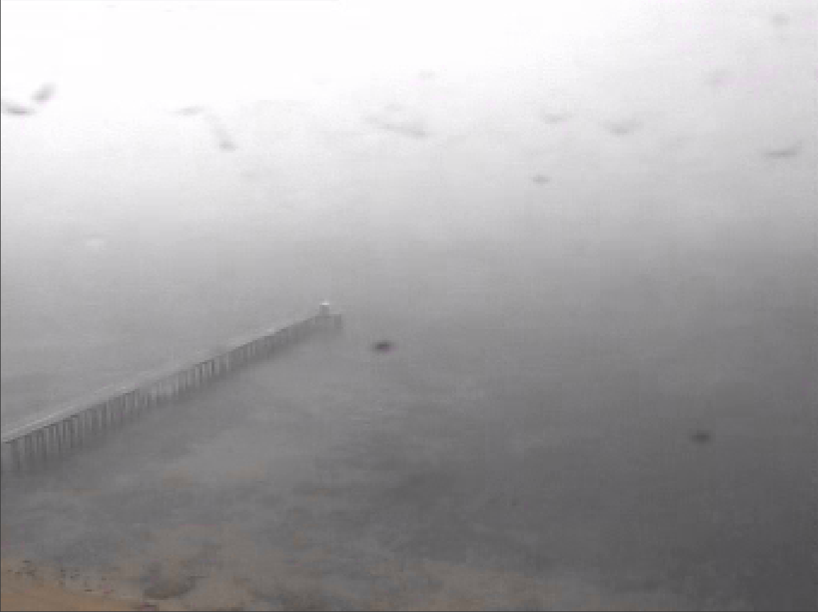 Figure 5: Still images taken at 1215 from two different closed-circuit television cameras owned by the Port of Melbourne. One camera (left image) was positioned on the Point Lonsdale lighthouse facing east. The other camera (right image) was positioned at Point Nepean, facing north. The image quality is affected by contaminants on the camera lens, but the extent of the low visibility conditions in the area is evident