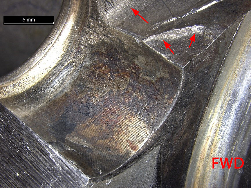 Figure 7: Corrosion observed within the bore of the dowel pin hole. Image show corrosion in bore, along with crack originating at the forward corner of the dowel pin hole (arrowed) Source: ATSB