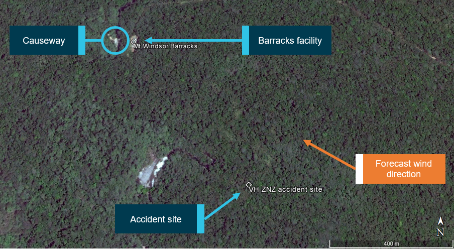 Figure 4: Accident site relative to barracks facility and causeway. Forecast wind direction indicating the accident site was located about 500–600 m upwind of the barracks facility and causeway.<br />
Source: Google earth, annotated by ATSB