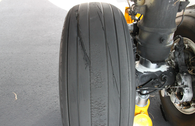 Figure 3: VH-VUI tyre damage. Image shows cut damage to the right main landing gear outboard tyre. The chevrons in the centre of the tread are normal. Source: ATSB