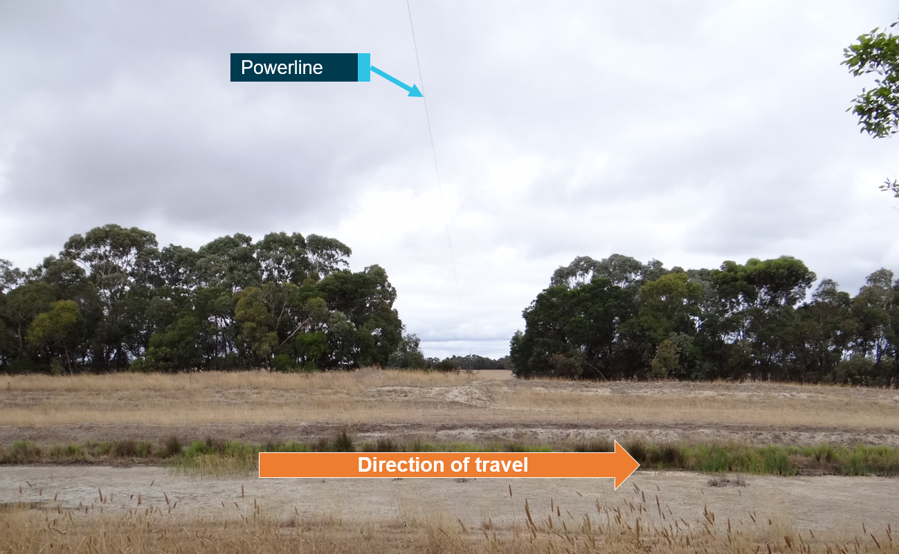 Figure 3: Powerline and drain boundary. Shows powerline in profile view, and vegetation obscuring power pole beyond edge of the drain. Source: SA Power Networks. Annotated by ATSB