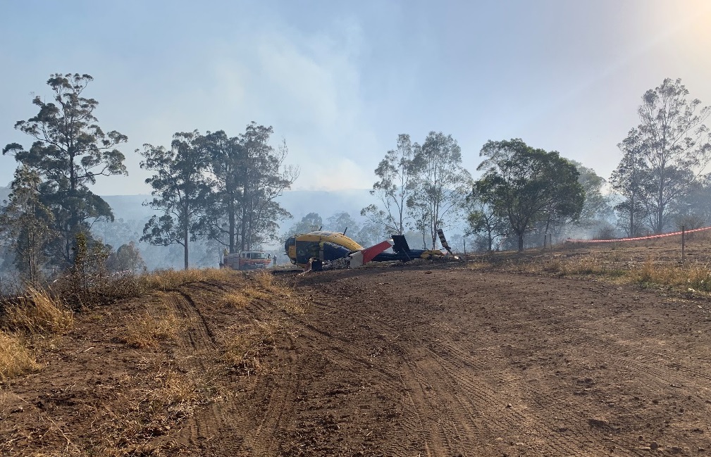 Figure 1: Aircraft prior to recovery – looking at reciprocal direction of approach. The final water drop occurred beyond the fuselage where the smoke is rising.<br />
Source: Operator