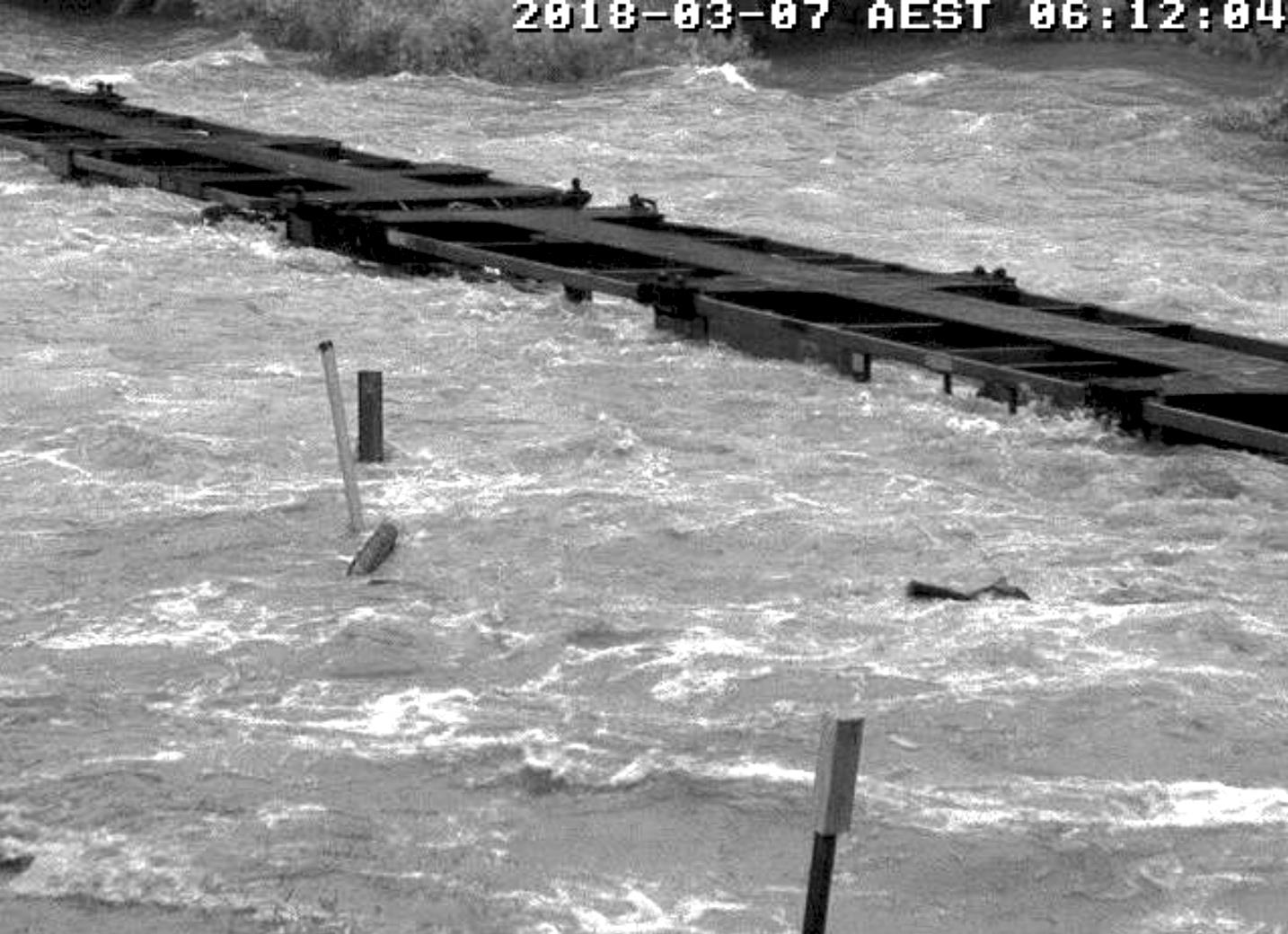 Figure 5: Empty container wagons behind train 6792’s locomotive, standing on the flooded Little Banyan Creek rail bridge.<br />
Source: QR.