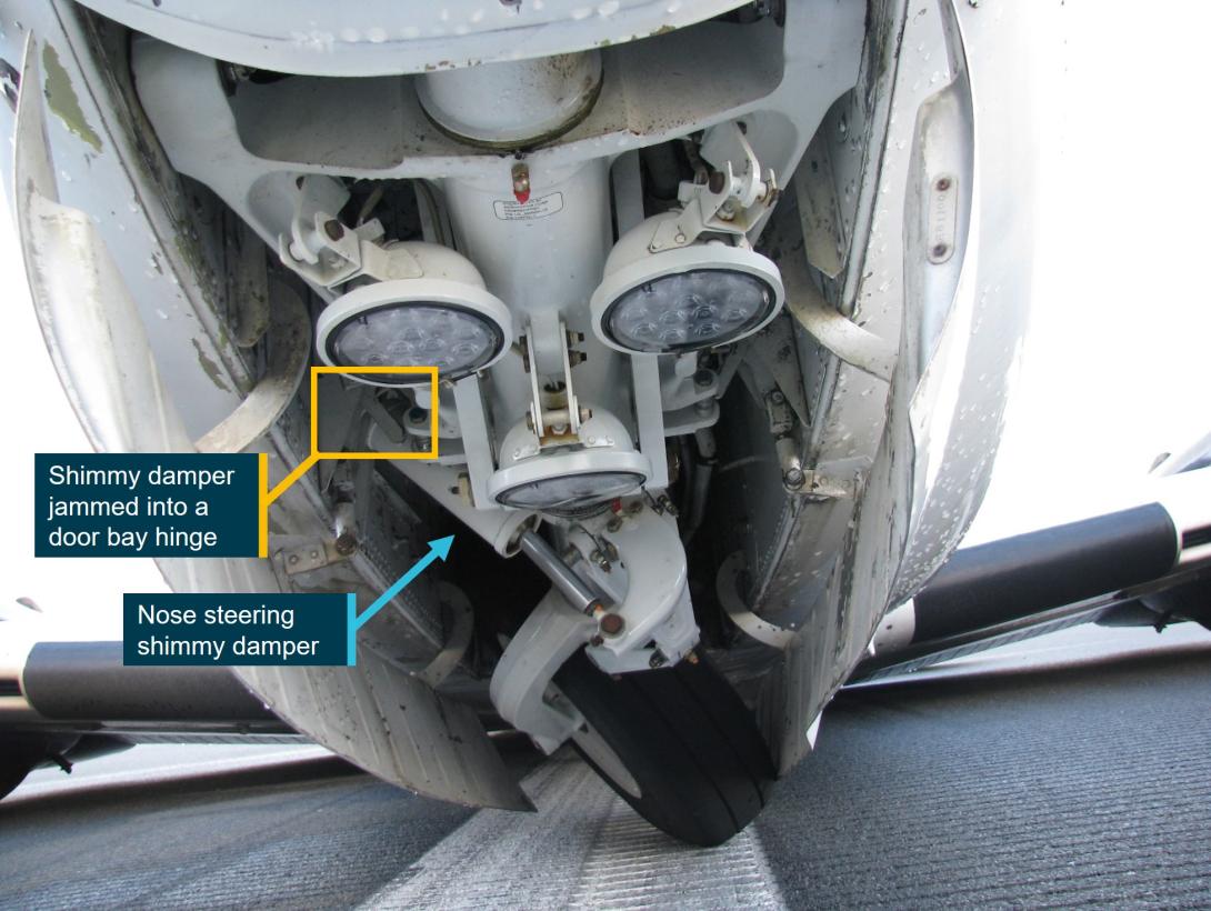 Figure 3: The nose landing gear tilted to the left with the shimmy damper jammed against a hinge in the undercarriage bay