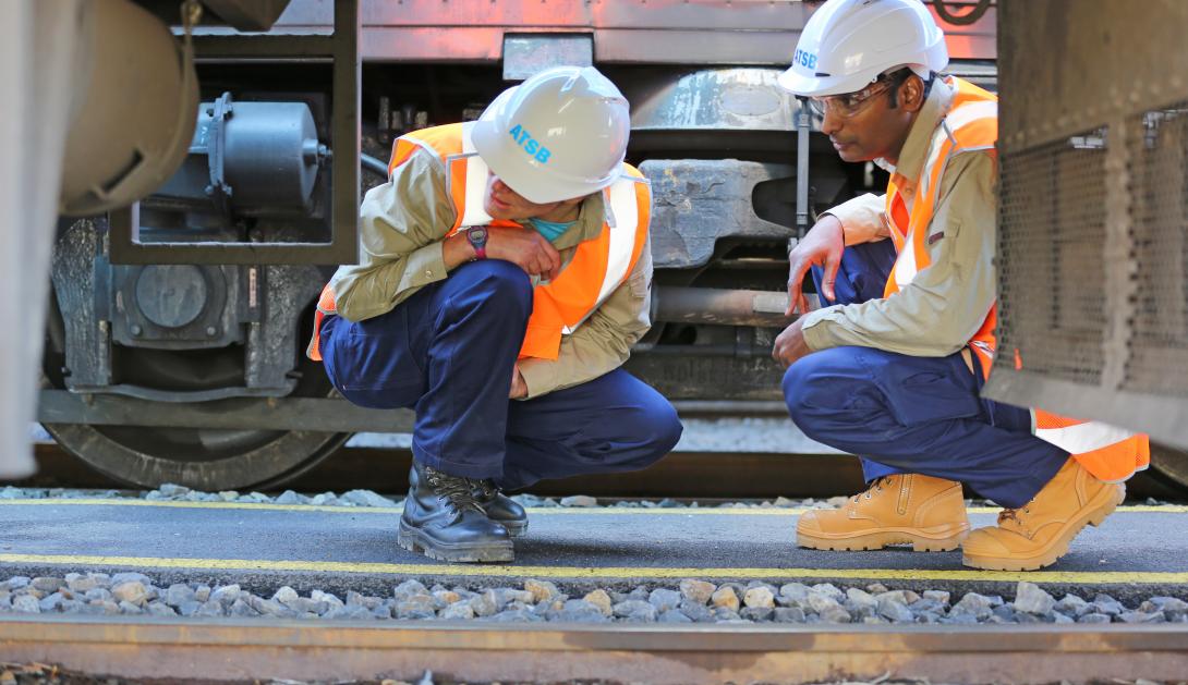 Two investigators looking at train wreckage